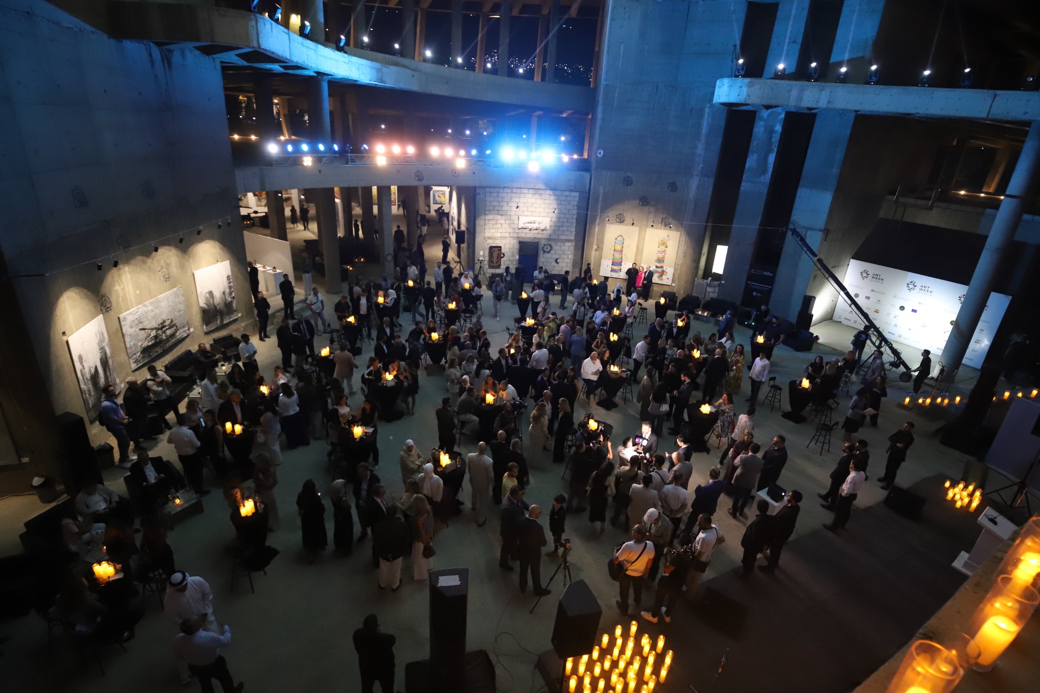 Guests gathered among artworks at the Art Week Syria reception in Masar Rose